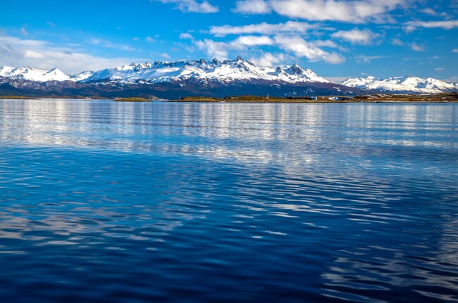 Snowy mountains behind a fjord.