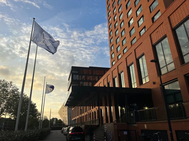 A flag flying outside a large building.