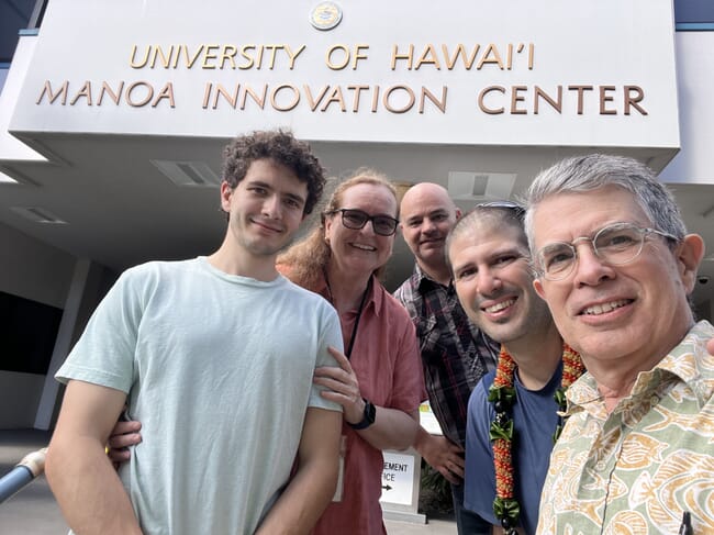 A group of people outside a university entrance.