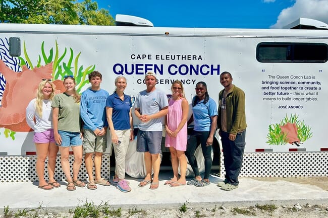 A group of researchers and volunteers standing infront of a mobile laboratory for conservation.