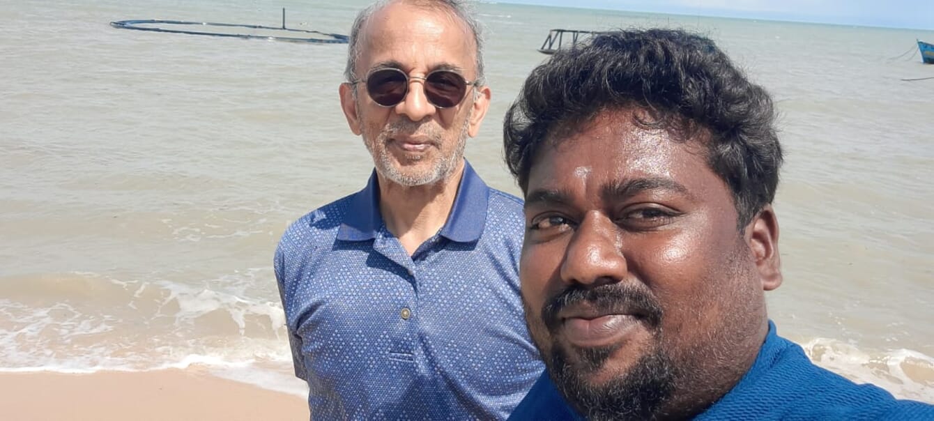 Two men visiting a seaweed farm in India on a sunny day.