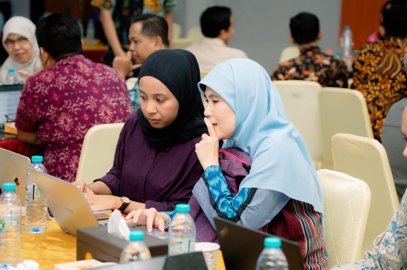 Two women discussing fish welfare in Indonesia.