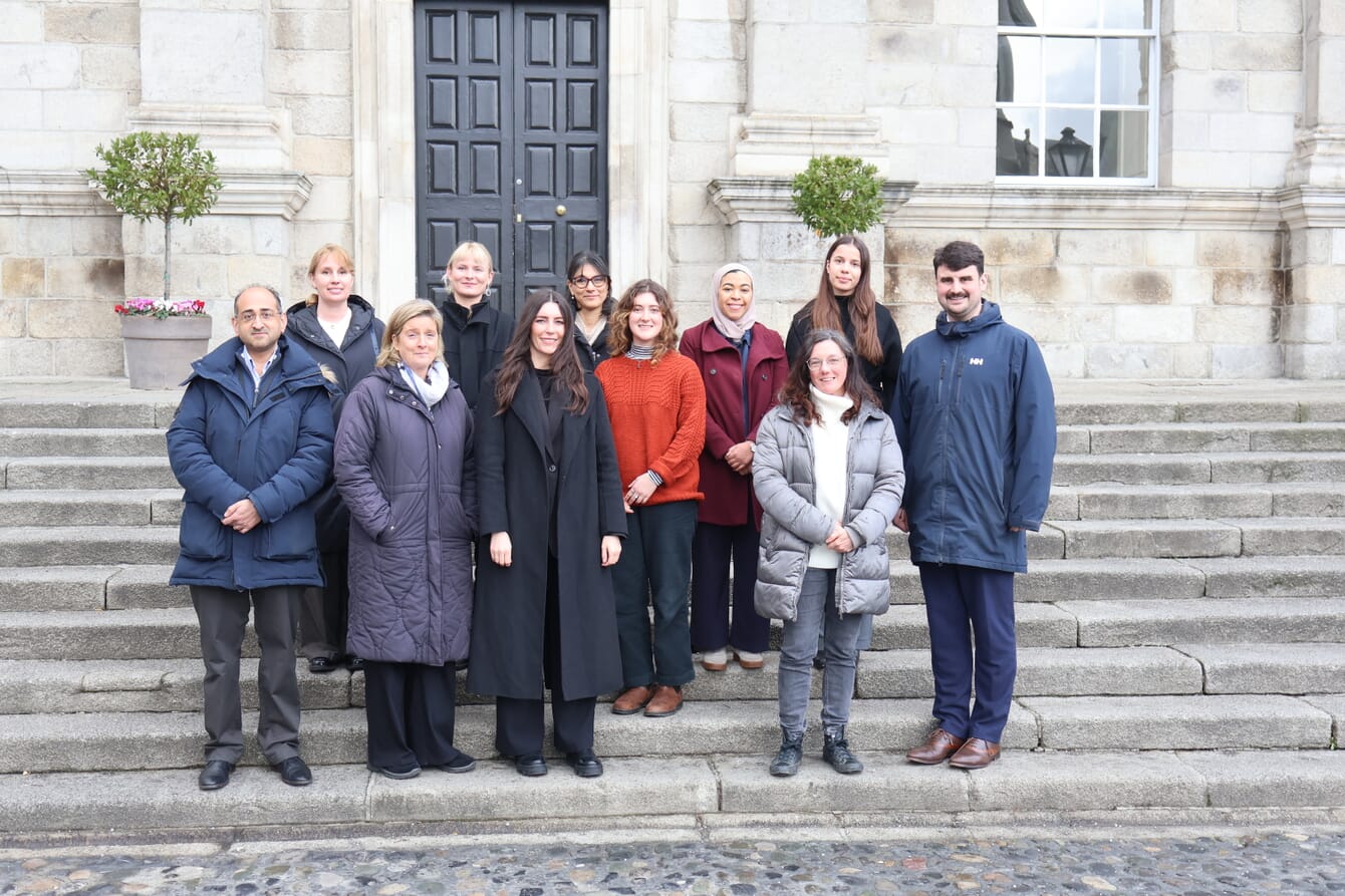 A group of people working in ocean science posing for a photo infront of a building.