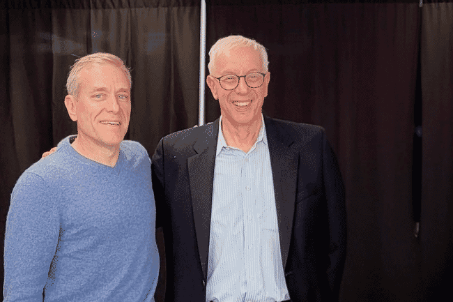 Two men posing for a photo after signing an agreement.